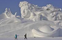 Visitors walk past a giant snow sculpture ahead of the 30th Harbin Ice and Snow Festival in Harbin, Heilongjiang province December 28, 2013. The festival kicks off on January 5, 2014. REUTERS/Sheng Li (CHINA - Tags: ENTERTAINMENT ENVIRONMENT SOCIETY TPX IMAGES OF THE DAY) CHINA OUT. NO COMMERCIAL OR EDITORIAL SALES IN CHINA