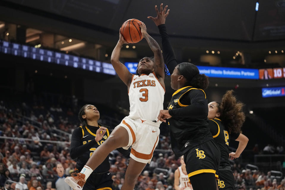 Texas guard Rori Harmon (3) drives to the basket against Long Beach State forward Davai Matthews, right, during the first half of an NCAA college basketball game in Austin, Texas, Wednesday, Dec. 6, 2023. (AP Photo/Eric Gay)