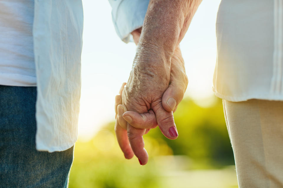 Senior couple holding hands. (Getty Images)