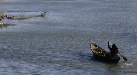 An Iraqi Marsh Arab woman paddles her boat at the Chebayesh marsh in Dhi Qar province, Iraq April 14, 2019. Picture taken April 14, 2019. REUTERS/Thaier al-Sudani