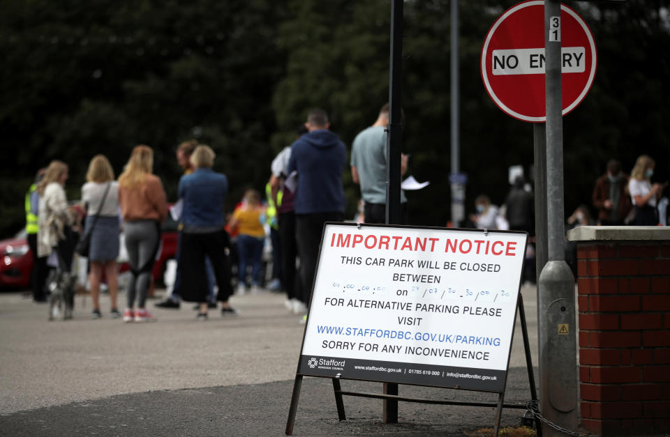 People queue near the Crown and Anchor pub following a spike in cases of the coronavirus disease (COVID-19) to visitors of the pub in Stone, Britain, July 29, 2020. REUTERS/Carl Recine