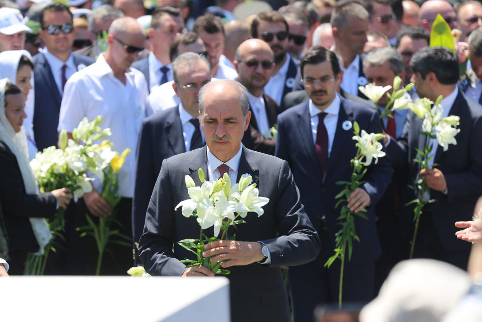 <p>Deputy Prime Minister of Turkey Numan Kurtulmus (C) holds a lily in his hands, which represents victims’ innocence, to mark the 22nd anniversary of the 1995 Srebrenica genocide in Potocari village of Srebrenica, Bosnia and Herzegovina on July 11, 2017. (Photo: Kemal Zorlak/Anadolu Agency/Getty Images) </p>
