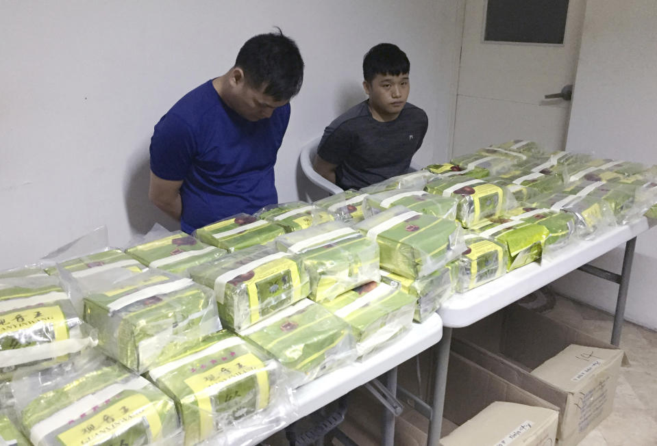 In this Tuesday, March 19, 2019, photo provided by the Philippine Drug Enforcement Agency, PDEA, two Chinese nationals are shown with more than 160 kilograms (353 pounds) of methamphetamine concealed in tea wrappers following "buy-bust" raids in Alabang township, Muntinlupa city east of Manila, Philippines. It was PDEA's second largest drug haul this year in a sign of how the problem has persisted despite the president's bloody crackdown on illegal drugs. Aquino said Wednesday, March 20, 2019, three Chinese nationals and a Chinese-Filipino man, who works as an interpreter, were arrested, with the drugs concealed in tea wrappers similar to those seized in Malaysia, Thailand and Myanmar and indicated an international drug syndicate was behind the trafficking. (Sheila Valmoria, Philippine Drug Enforcement Agency PIO via AP)