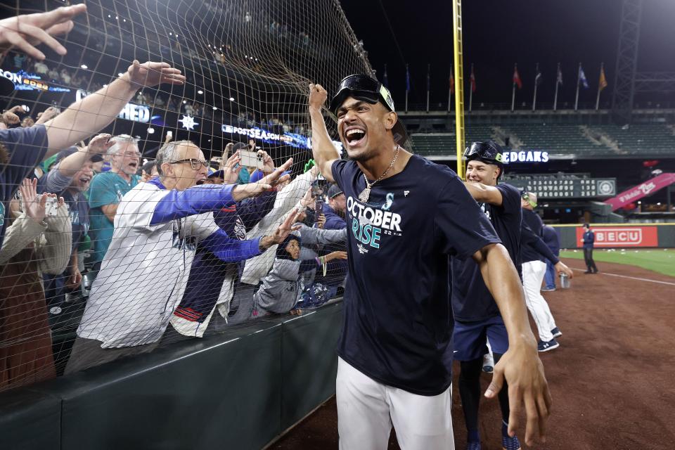 SEATTLE, WASHINGTON - SEPTEMBER 30: Julio Rodriguez #44 of the Seattle Mariners celebrates with fans after clinching a postseason birth after beating the Oakland Athletics 2-1 at T-Mobile Park on September 30, 2022 in Seattle, Washington. The Seattle Mariners have clinched a postseason appearance for the first time  in 21 years, the longest playoff drought in North American professional sports. (Photo by Steph Chambers/Getty Images)