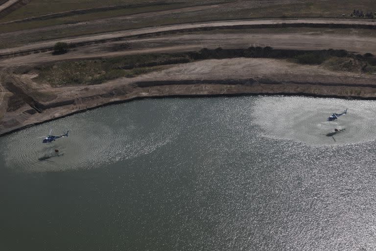 Los helicópteros cargan agua en un lago cercano al terreno incendiado