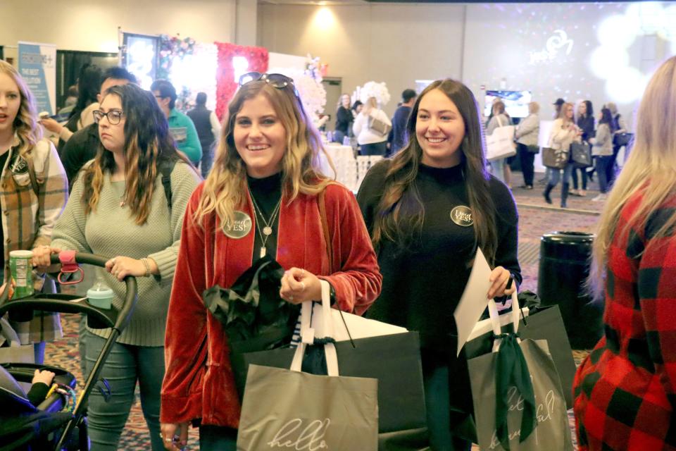 Mackensie Dodson and Kamryn Benavidez have fun collecting samples at the 2023 Amarillo Bridal Show held at the Amarillo Civic Center Sunday afternoon.