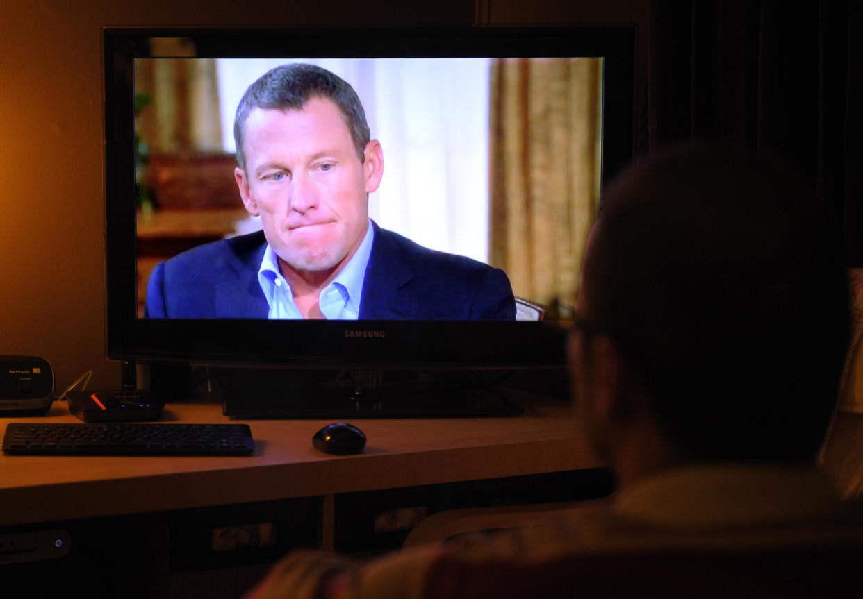 A photo illustration shows a man watching a TV showing disgraced cycling star Lance Armstrong being interviewed by Oprah Winfrey on January 17, 2013 in  Kensington, Maryland. Armstrong said in the interview that he was 