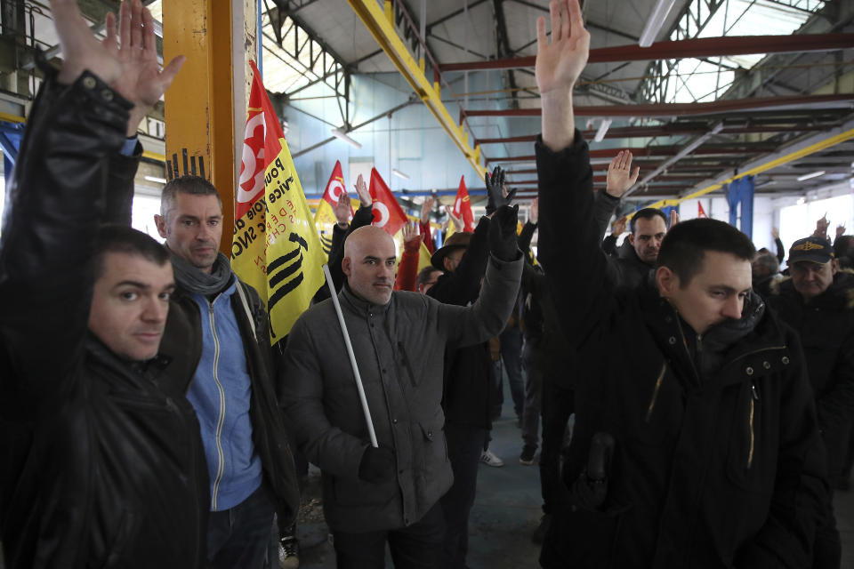Railway workers votes during a meeting of the CGT union in Rennes, western France, Monday, Dec. 9, 2019. Unions launched nationwide strikes and protests over the government's plan to overhaul the retirement system. Paris commuters inched to work Monday through exceptional traffic jams, as strikes to preserve retirement rights halted trains and subways for a fifth straight day. (AP Photo/David Vincent)