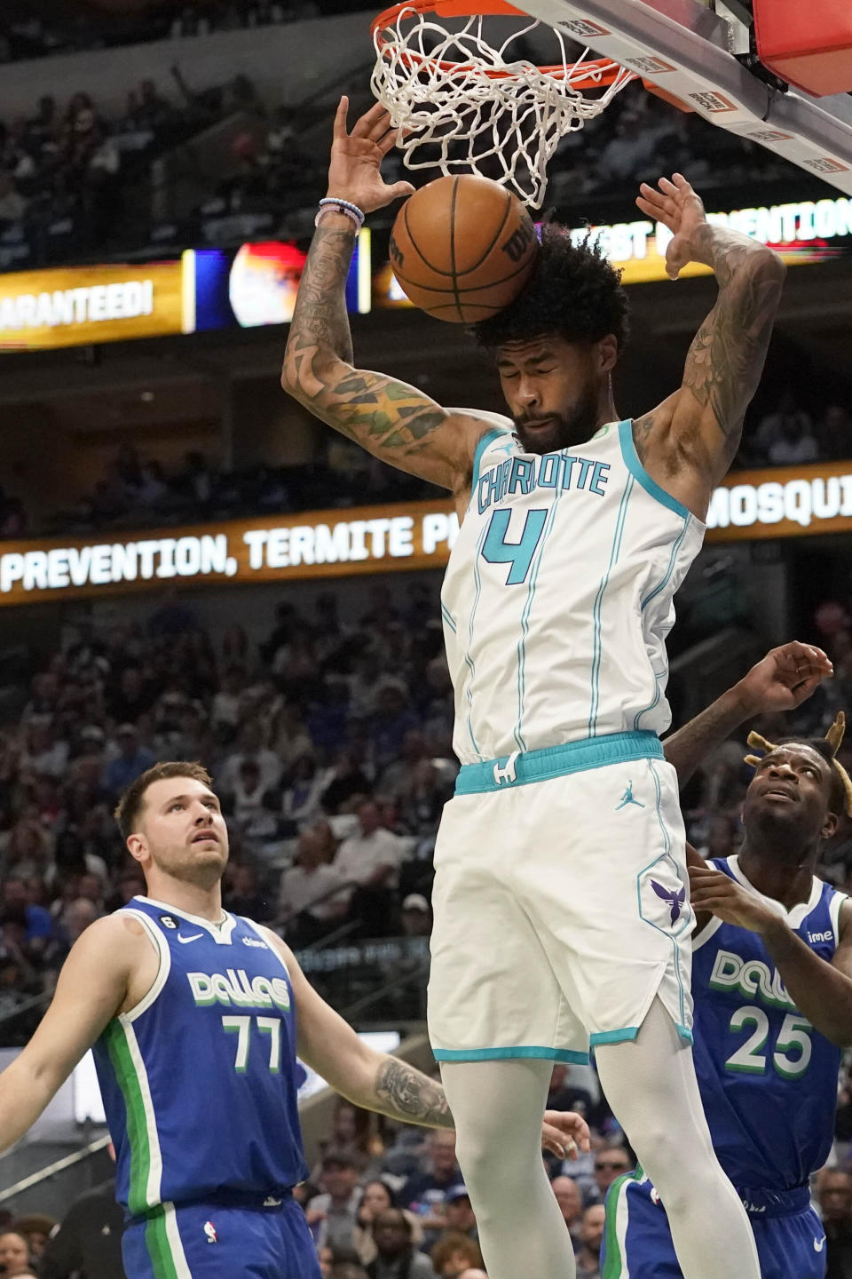 Charlotte Hornets center Nick Richards (4) dunks against Dallas Mavericks defenders Luka Doncic (77) and Reggie Bullock (25) during the first quarter of an NBA basketball game in Dallas, Friday, March 24, 2023. (AP Photo/LM Otero)