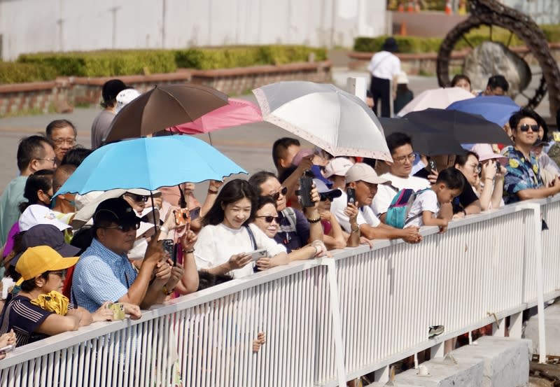 高雄天氣晴朗  大港橋現人潮（1） 中央氣象署22日下午發布台南、高雄、台東及屏東高 溫資訊及燈號，氣象署觀測，午後高雄內門氣溫一度 飆升至攝氏38.4度。圖為高雄駁二藝術特區周邊，民 眾撐傘、戴墨鏡遮陽，享受陽光假期。 中央社記者董俊志攝  113年4月22日 