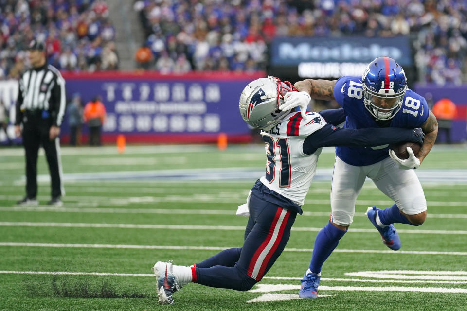 New York Giants wide receiver Isaiah Hodgins (18) avoided a tackle by New England Patriots cornerback Jonathan Jones (31) during the second quarter of an NFL football game, Sunday, Nov. 26, 2023, in East Rutherford, N.J. (AP Photo/Seth Wenig)