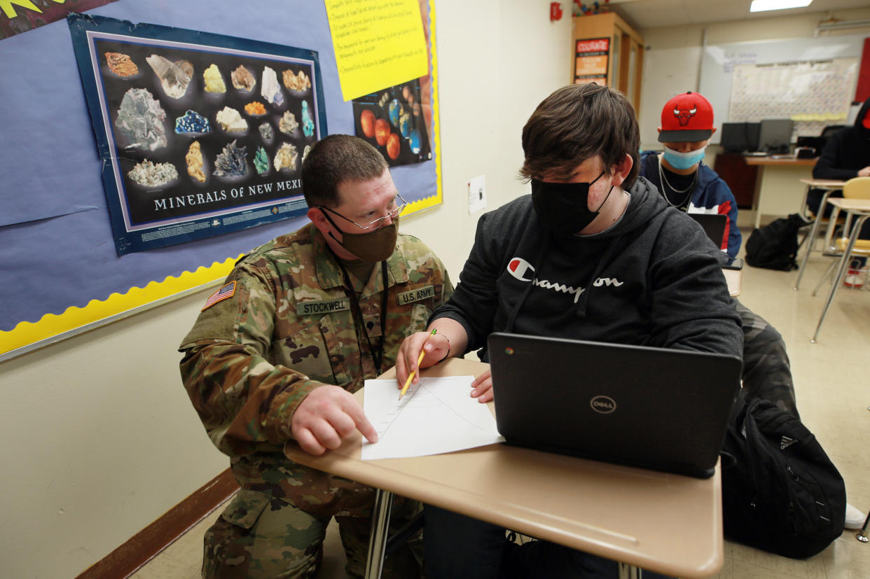 Substitute teacher and New Mexico Army National Guard specialist Michael Stockwell helps Alamogordo High School freshman Aiden Cruz with a geology assignment. (AP)