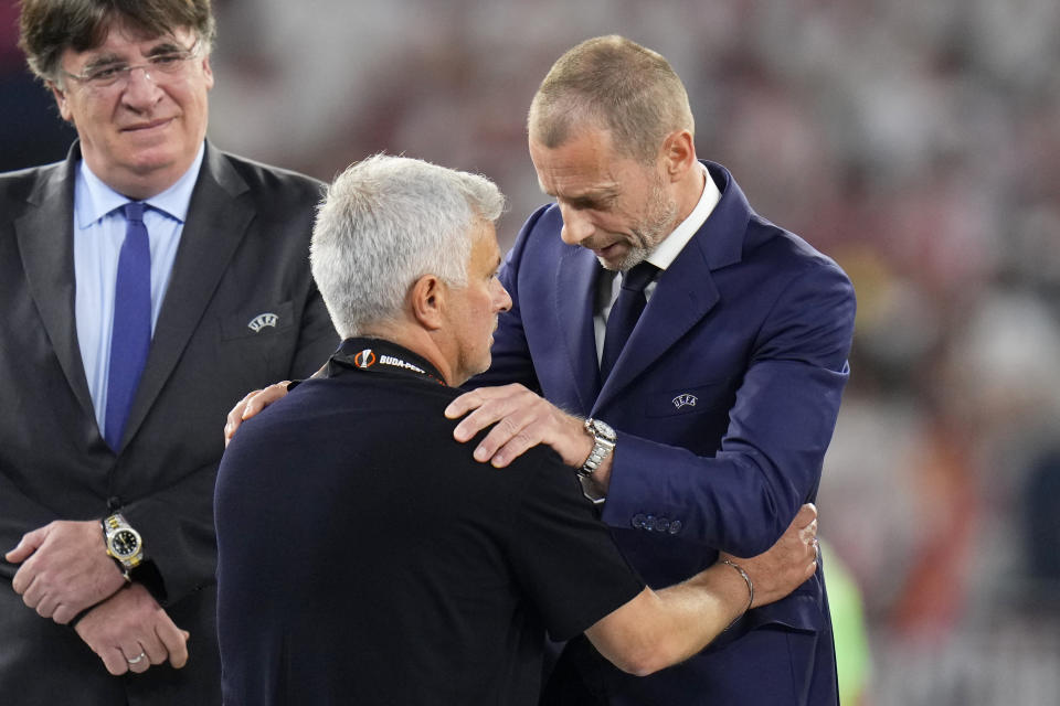 UEFA president Aleksander Ceferin, right, talks with Roma's head coach Jose Mourinho after awarding him his second place medal at the end of the Europa League final soccer match between Sevilla and Roma, at the Puskas Arena in Budapest, Hungary, Wednesday, May 31, 2023. Sevilla defeated Roma 4-1 in a penalty shootout after the match ended tied 1-1. (AP Photo/Petr David Josek)