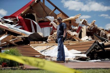 Una persona frente a una vivienda destrozada por un tornado en Canton, Texas, EEUU, Abril 30, 2017. Múltiples tornados atravesaron una ciudad en el este de Texas y causaron la muerte de al menos cuatro personas y heridas a decenas de otras en la noche del sábado, al tiempo que fuertes vientos, caída de árboles e inundaciones en ciudades vecinas también provocaron el fallecimiento de cinco personas, de acuerdo a reportes de prensa. REUTERS/Brandon Wade