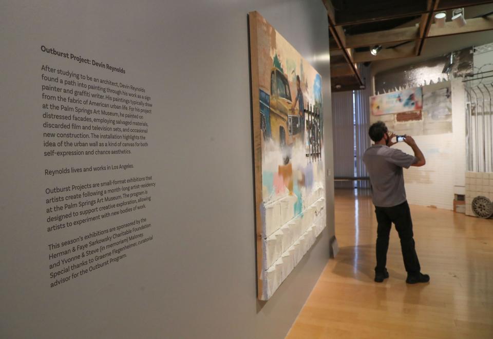 A man takes a photo of the "Outburst Project" by Devin Reynolds during the debut of new spring exhibits at the Palm Springs Art Musuem in Palm Springs, Calif., April 21, 2022. 