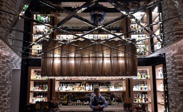 A member of staff wipes a glass in Les Menus restaurant in Moscow on March 23, 2015