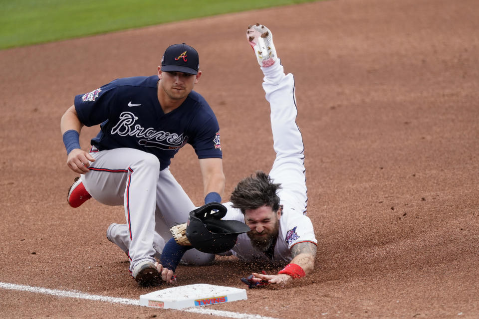 Minnesota Twins' Jake Cave, right, is tagged out by Atlanta Braves third baseman Austin Riley, left, at third base as he tries to advance on a teammates base hit in the second inning of a spring training baseball game against the Atlanta Braves Monday, March 22, 2021, in Fort Myers, Fla. (AP Photo/John Bazemore)