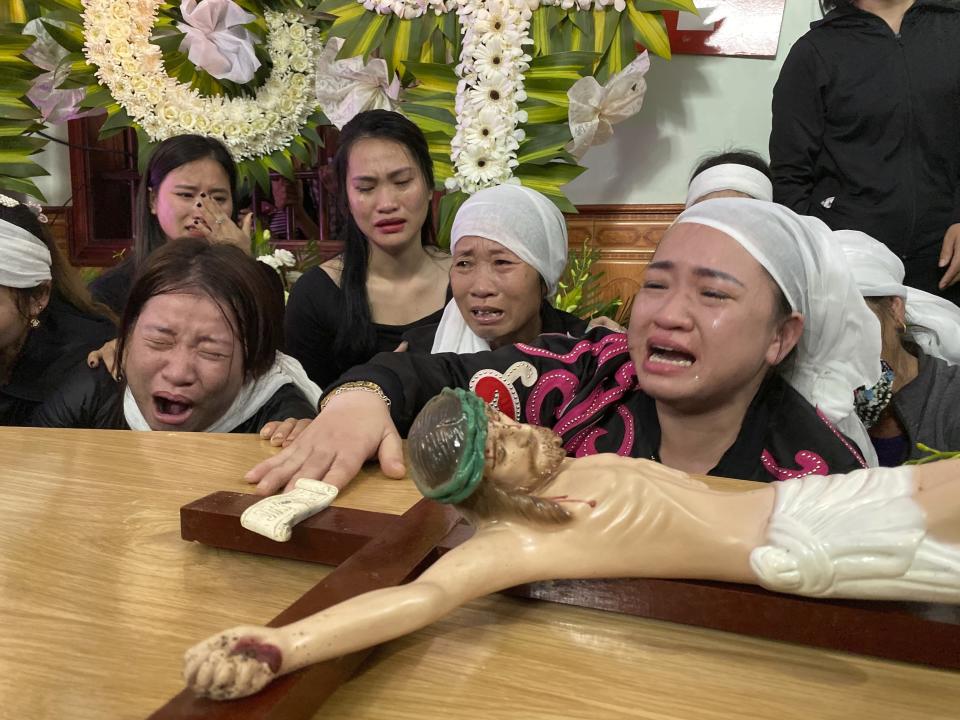 Relatives of Bui Thi Nhung weep next to Nhung's casket at the family home on Saturday, Nov. 30, 2019 in the village of Do Thanh, Vietnam. The body of 19-year old Nhung was among the last remains of the 39 Vietnamese who died while being smuggled in a truck to England last month that were repatriated to their home country on Saturday. (AP Photo/Hau Dinh)