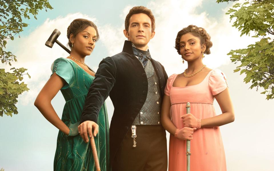 Zwischen Anthony (Jonathan Bailey) und den beiden Schwestern Kate (Simone Ashley, links) und Edwina (Charithra Chandran) entwickelt sich eine Dreiecksbeziehung. (Bild: Netflix)