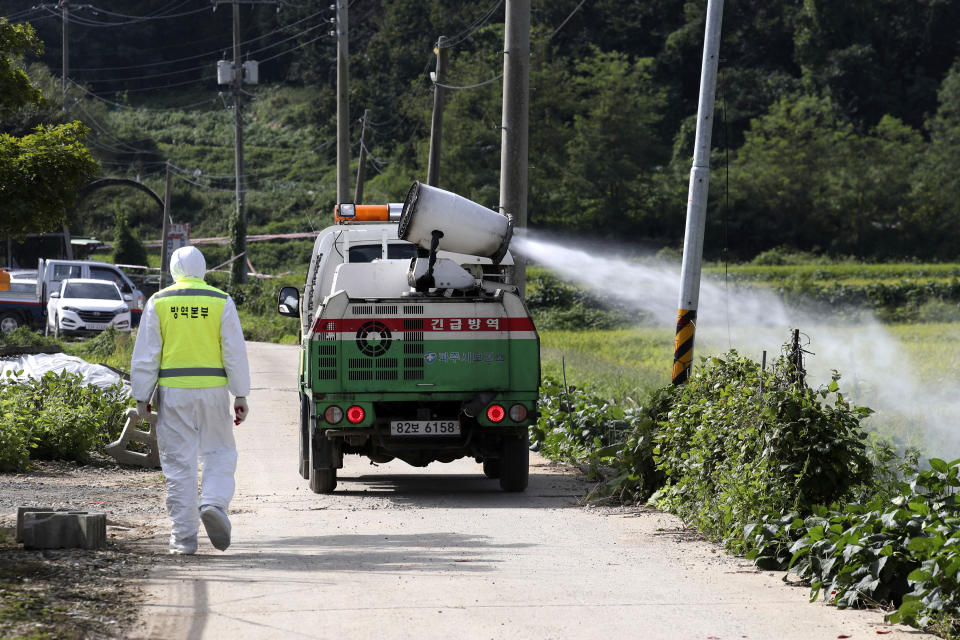 Disinfectant solution is sprayed from a vehicle as a precaution against African swine fever at a pig farm in Paju, South Korea, Tuesday, Sept. 17, 2019. South Korea is culling thousands of pigs after confirming African swine fever at a farm near its border with North Korea, which had an outbreak in May. (Lim Byung-shick/Yonhap via AP)