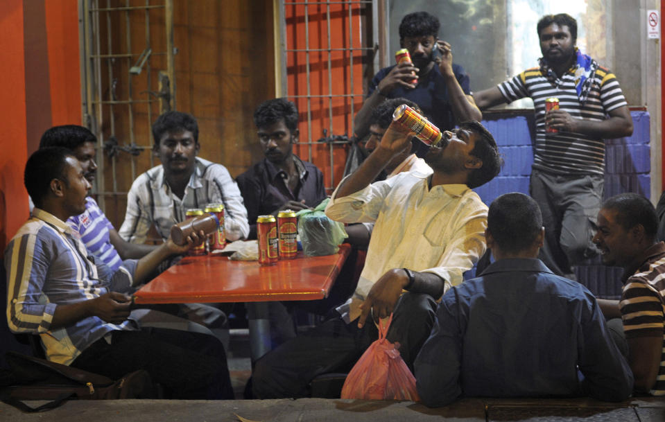 In this photo taken Feb. 9, 2014, migrant workers enjoy their day off in Singapore's Little India District. Singapore’s wealth and continued growth rely in large part on foreign workers. Yet as the numbers of migrant workers soar, tales of abuse and exploitation are threatening to take some of the shine off the city-state’s international reputation.(AP Photo/Joseph Nair)