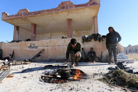 Fighters from the Democratic Forces of Syria start a fire to boil water in the 121 Regiment base, after taking control of it from Islamic State militants in the town of al-Melabiyyah, south of Hasaka city, Syria November 24, 2015. REUTERS/Rodi Said