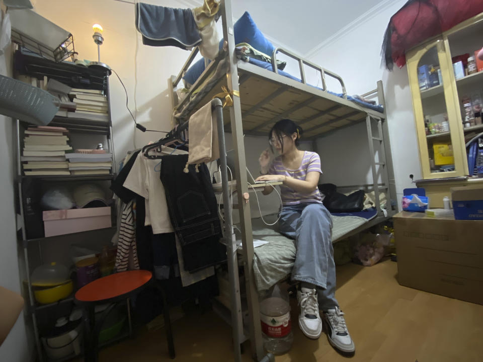 Recent college graduate Liu Qian works on her laptop computer in the room she rents in an apartment in Beijing, Thursday, July 7, 2022. Liu is one of 11 million new graduates desperate for work in a bleak job market as anti-virus controls force factories, restaurants and other employers to close. The survivors are cutting jobs and wages. (AP Photo/Olivia Zhang)