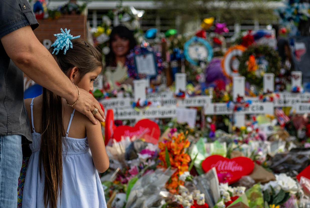 Image: Seth Garza and his daughter, Lilly, pause at a memorial dedicated to the 19 children and two adults killed during a mass shooting at Robb Elementary School in Uvalde, Texas, on May 31, 2022. (Brandon Bell / Getty Images file)