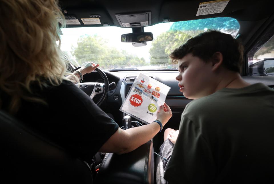 Emilie Campbell uses a page of pictures to ask her son Connor Campbell, 16, to point to what he’d like to do while taking a drive in Provo on Sunday, May 28, 2023. Connor is autistic, nonverbal and has epilepsy. He lives at the Utah State Developmental Center in American Fork but comes home on Sundays. | Kristin Murphy, Deseret News