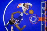 New York Knicks' Donte DiVincenzo, right, goes up to shoot against Philadelphia 76ers' Joel Embiid, left, during the second half of Game 6 in an NBA basketball first-round playoff series, Thursday, May 2, 2024, in Philadelphia. (AP Photo/Matt Slocum)