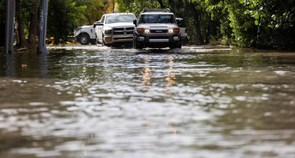 Vehicles make their way down a flooded street near Little River Pocket Park on Monday, Oct. 30, 2023 in Miami, Fla. Monday was the highest king tide of the year for South Florida, flooding streets, driveways and parks. MATIAS J. OCNER/mocner@miamiherald.com