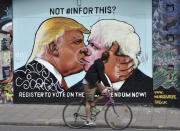 <p>A cyclist glances at a painted image of former London Mayor Boris Johnson, right, and U.S. presidential candidate Donald Trump in Stokes Croft in Bristol, England, on May 30, 2016. (Neil Munns/EPA) </p>