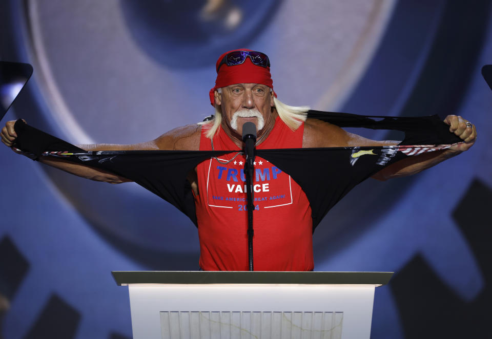 Hulk Hogan zerreißt ein Hemd, während er auf einem Podium steht, mit einem roten Bandana, einer Sonnenbrille und einem ärmellosen "Trump-Pence" Hemd