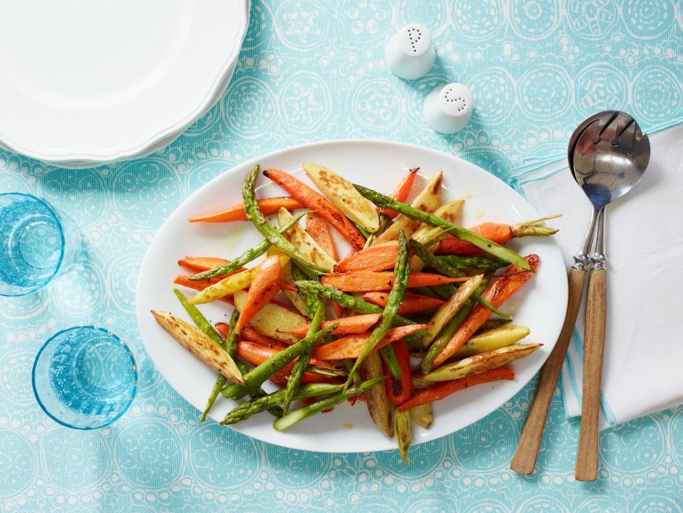 orange roasted potatoes, carrots, and asparagus on a white dish