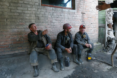 Miners smoke before descending into the Novovolynska-9 coal mine in Novovolynsk, Ukraine August 2, 2018. Picture taken August 2, 2018. REUTERS/Valentyn Ogirenko