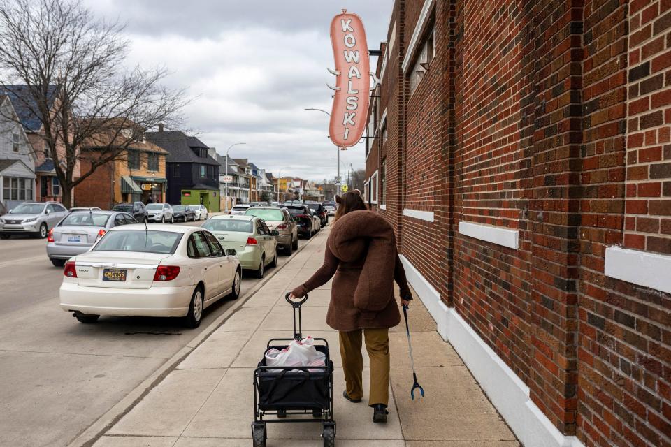 Lynn Blasey, 40, program manager of the Community Arts Partnerships office at the College for Creative Studies, walks next to the Kowalski Sausage Co. factory on Saturday, March 9, 2024, while cleaning up trash around her neighborhood in Hamtramck.