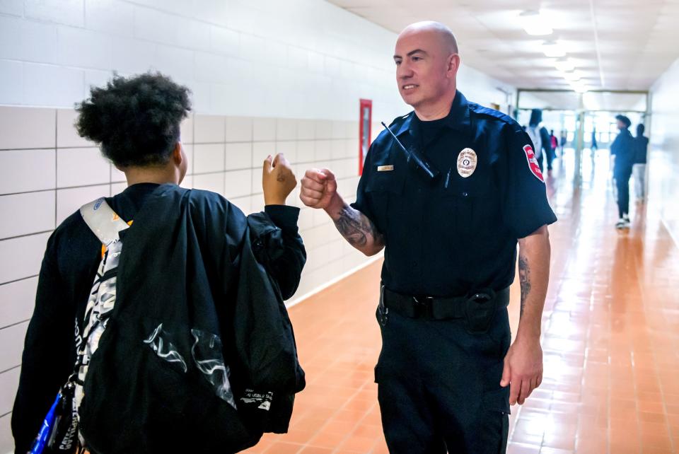 Manual High School resource officer Dylan Latta fist bumps a passing student in the hallway as classes change. Latta has only been on the job a few months after a long career as a delivery driver.