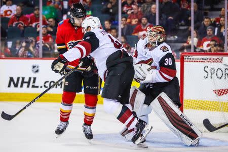 Feb 18, 2019; Calgary, Alberta, CAN; Calgary Flames right wing Garnet Hathaway (21) and Arizona Coyotes defenseman Ilya Lyubushkin (46) battle for the puck in front of Arizona Coyotes goaltender Calvin Pickard (30) during the third period at Scotiabank Saddledome. Calgary Flames won 5-2. Mandatory Credit: Sergei Belski-USA TODAY Sports