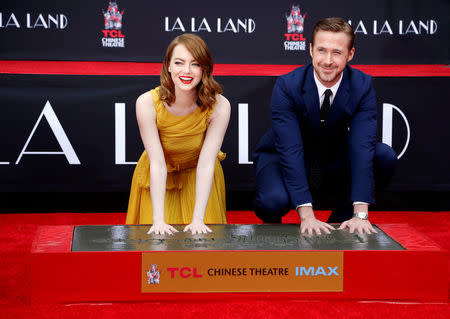 Actors Emma Stone and Ryan Gosling place their handprints in cement during a ceremony in the forecourt of the TCL Chinese theatre in Hollywood, California U.S., December 7, 2016. REUTERS/Mario Anzuoni