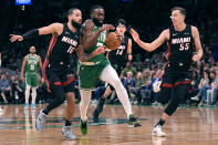 Boston Celtics guard Jaylen Brown, center, drives to the basket between Miami Heat's Caleb Martin (16) Duncan Robinson (55) during the first half of Game 2 of an NBA basketball first-round playoff series, Wednesday, April 24, 2024, in Boston. (AP Photo/Charles Krupa)