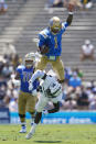 UCLA Bruins quarterback Dorian Thompson-Robinson (1) jumps over Hawaii Warriors defensive back Chima Azunna (0) during the first half of an NCAA college football game Saturday, Aug. 28, 2021, in Pasadena, Calif. (AP Photo/Ashley Landis)