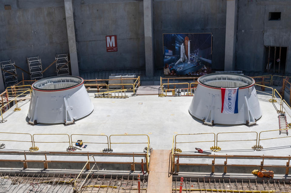 two white cylindrical objects sit on a cement floor