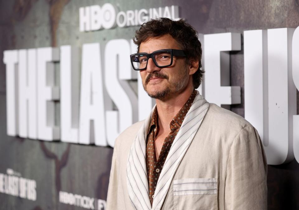 pedro pascal turning to his left and smiling for a photo at an event for the last of us