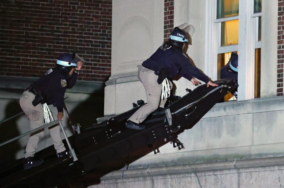 NYPD officers use a tactical ramp to break into Hamilton Hall, which had been renamed Hind Hall by protesters occupying it (AFP via Getty Images)