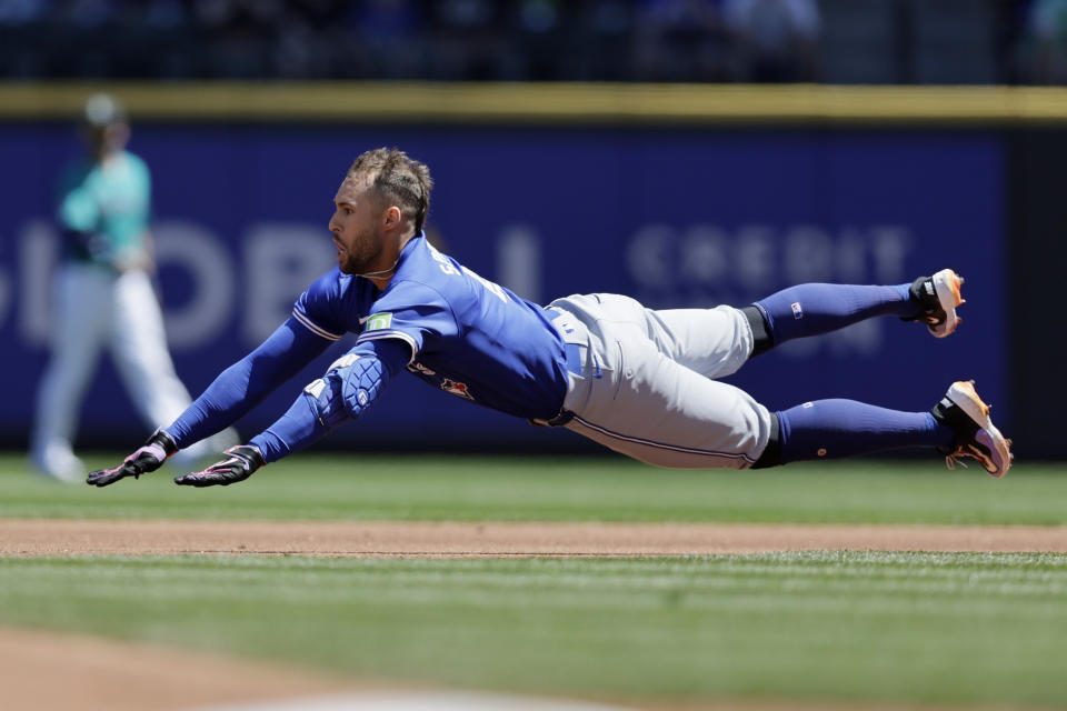 Toronto Blue Jays' George Springer dives into second for a double against the Seattle Mariners during the first inning in a baseball game, Saturday, July 6, 2024, in Seattle. (AP Photo/John Froschauer)