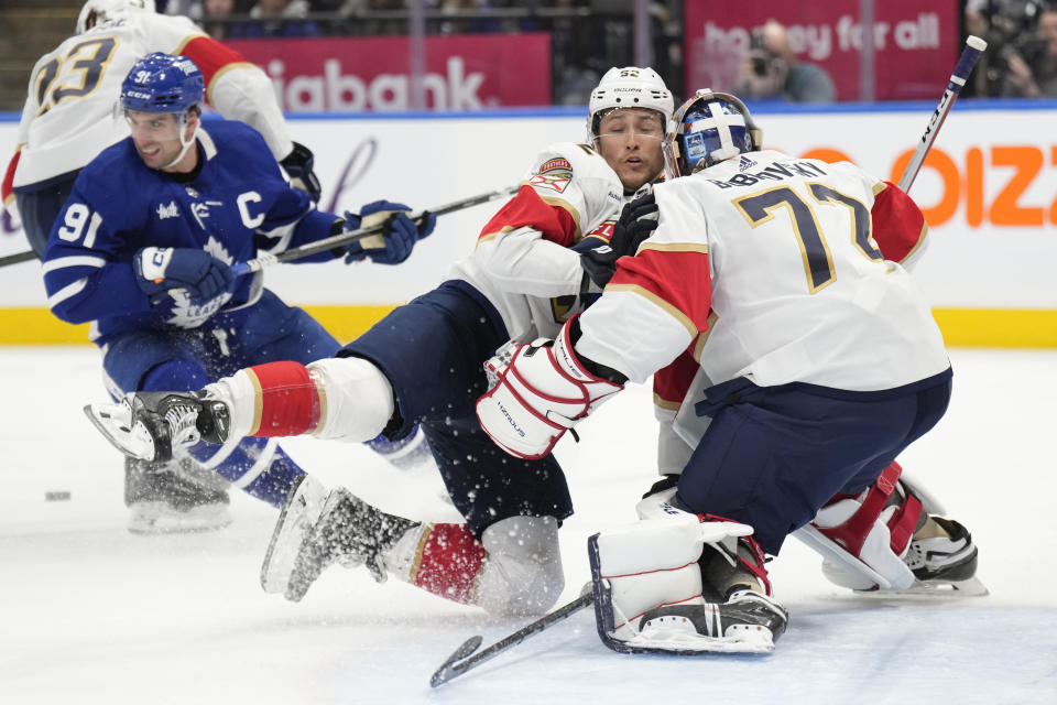 Florida Panthers defenseman Brandon Montour skates into his goaltender Sergei Bobrovsky (72) as Toronto Maple Leafs center John Tavares (91) looks up ice during the second period of an NHL hockey game in Toronto on Monday, April 1, 2024. (Frank Gunn/The Canadian Press via AP)