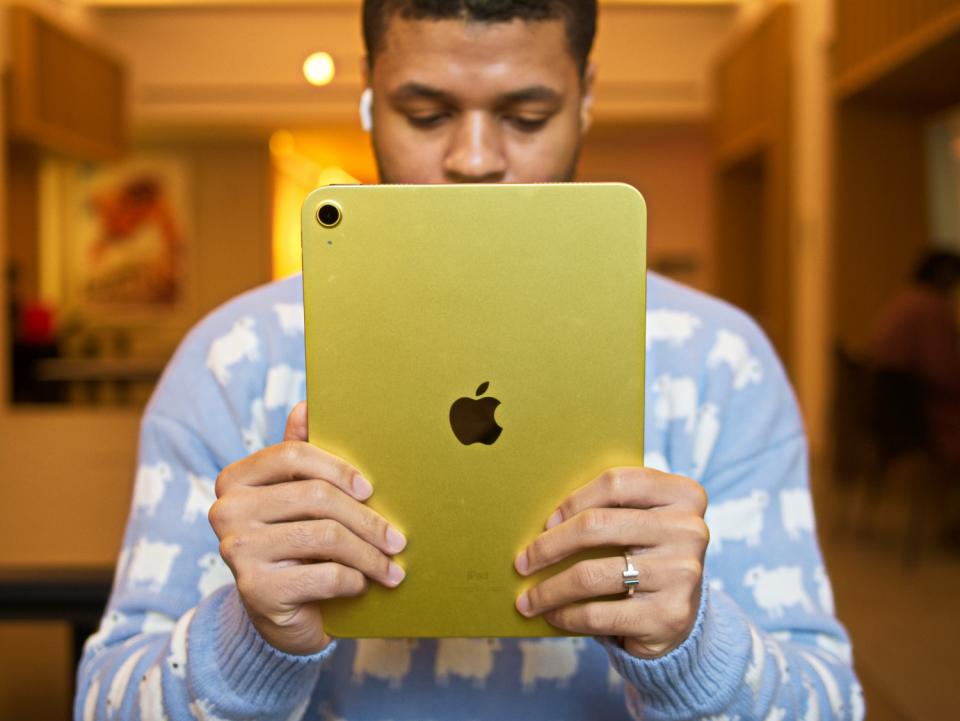 SPY editor Joseph Cheatham holding Apple iPad (10th Gen) in his hands.