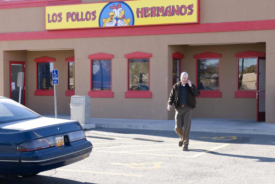 This publicity image released by AMC shows Bryan Cranston as Walter White walking away from the Los Pollos Hermanos, a set from the series "Breaking Bad." A few nondescript locations around Albuquerque have become famous in just the last few years thanks to AMC’s hit television series “Breaking Bad.” Go online, print out a free map to the filming locations scattered around the city and don’t forget your camera or smartphone. You won’t be able to resist taking a “selfie” in front of Los Pollos Hermanos or the Dog House Drive In. (AP Photo/AMC, Richard Foreman)