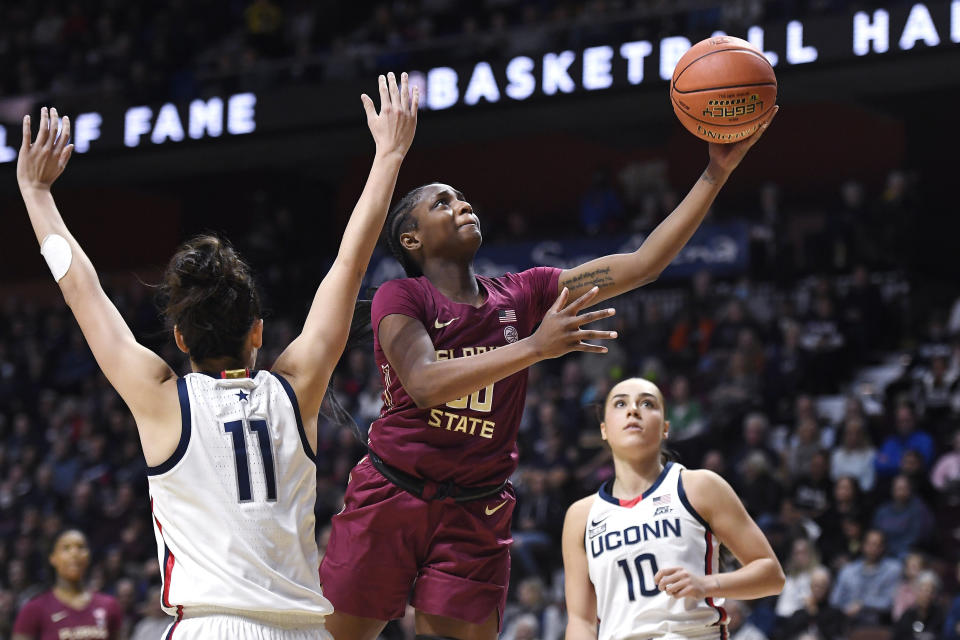 FILE - Florida State's Ta'niya Latson goes up for a basket as Connecticut's Lou Lopez-Senechal (11) defends during the second half of an NCAA college basketball game, Sunday, Dec. 18, 2022, in Uncasville, Conn. Latson — a 5-foot-8 guard who averaged 21.3 points and was named league rookie of the year — is among the eight players who returned from the 10-player all-ACC first team from last year.(AP Photo/Jessica Hill, File)