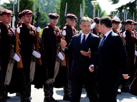 FILE PHOTO: Macedonian Prime Minister Nikola Gruevski (R) and his Hungarian counterpart Viktor Orban review a military guard of honor in Skopje May 12, 2011. REUTERS/Ognen Teofilovski/File Photo